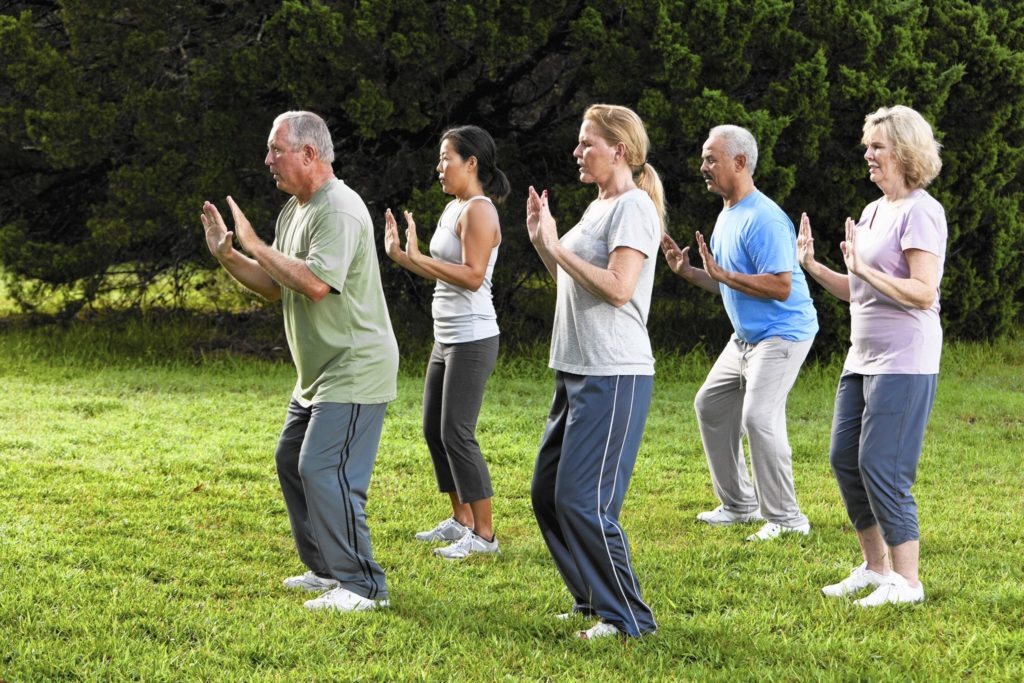 Tai Chi Class taking place outside in a park.