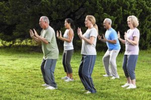 Group performing Tai Chi outdoors.