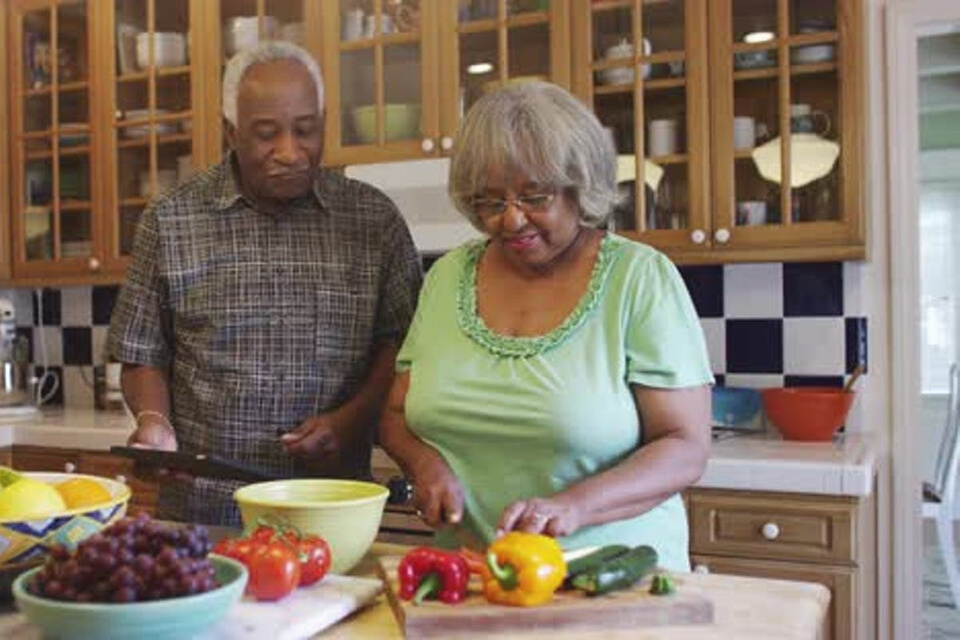 Older couple preparing a healthy meal together.