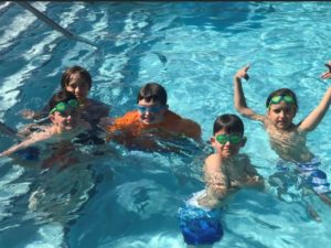 Children play in the pool at 4-H camp