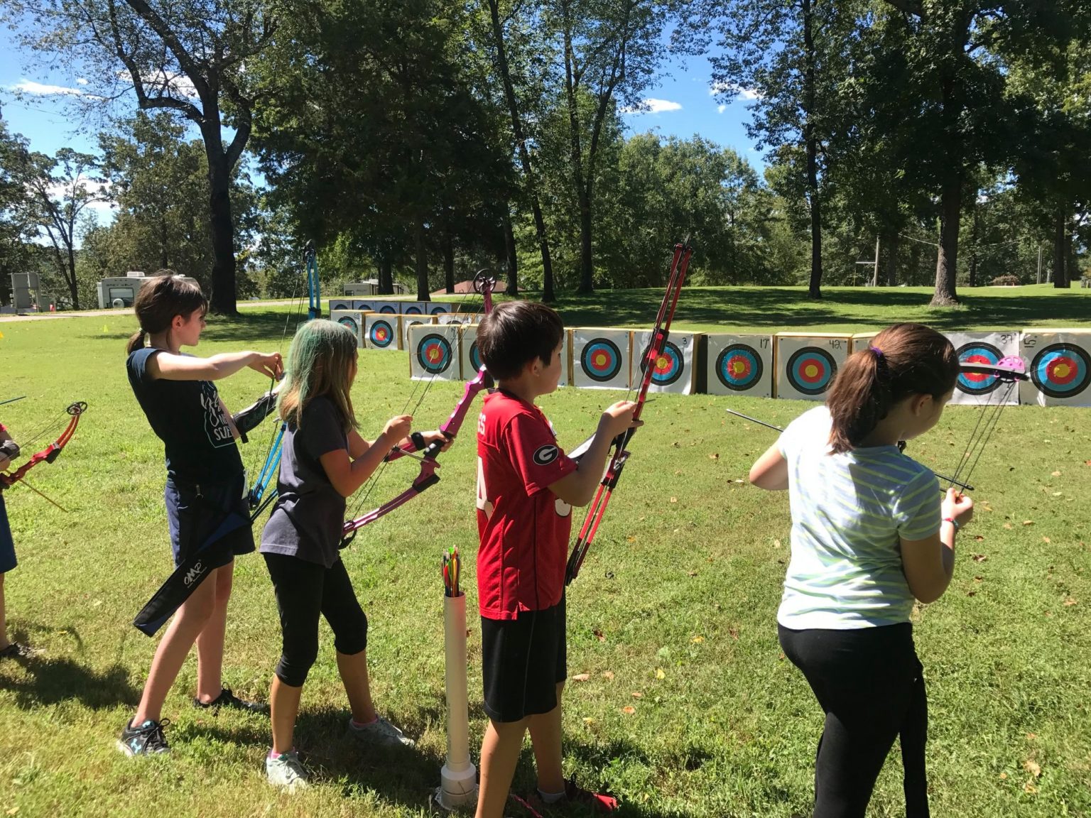 youth practicing archery outdoors