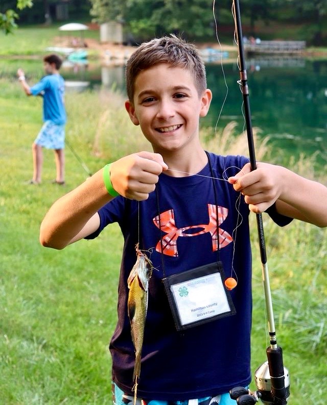 Boy holding up a fish he caught