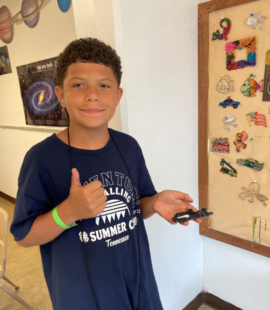 A boy holding an art project he made