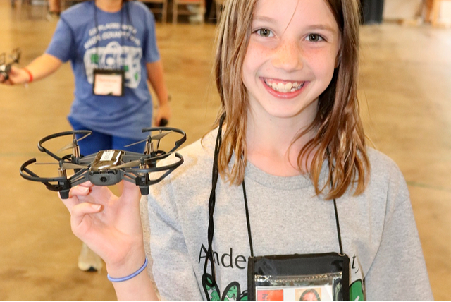 A girl holds a drone