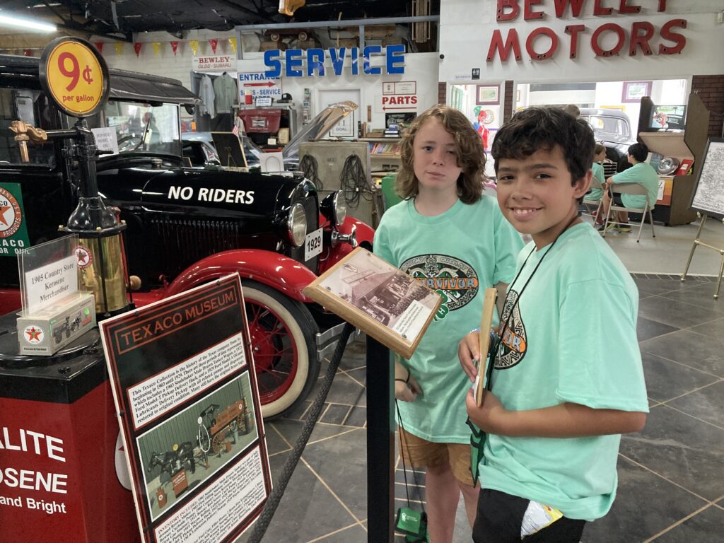 Two teens looking at cars at a museum