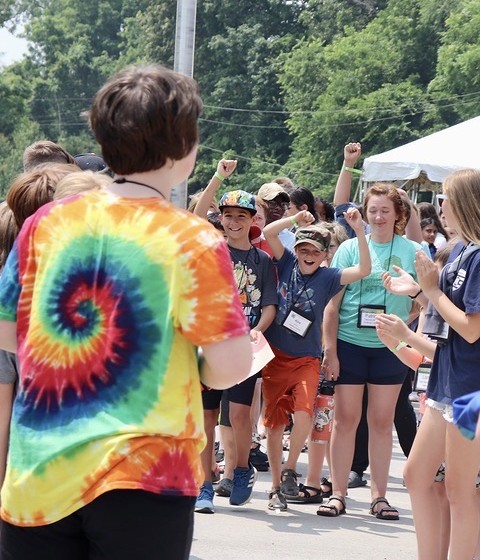 A group of children at camp cheer as they arrive