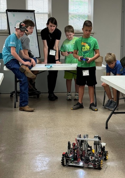 a boy drives a robot while other children watch