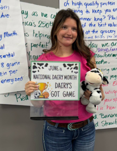 a girl holding a sign about dairy products poses for a photo
